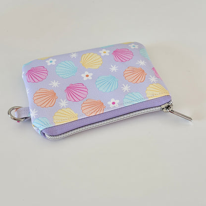 purple vegan leather coin purse with seashell pattern on a white background