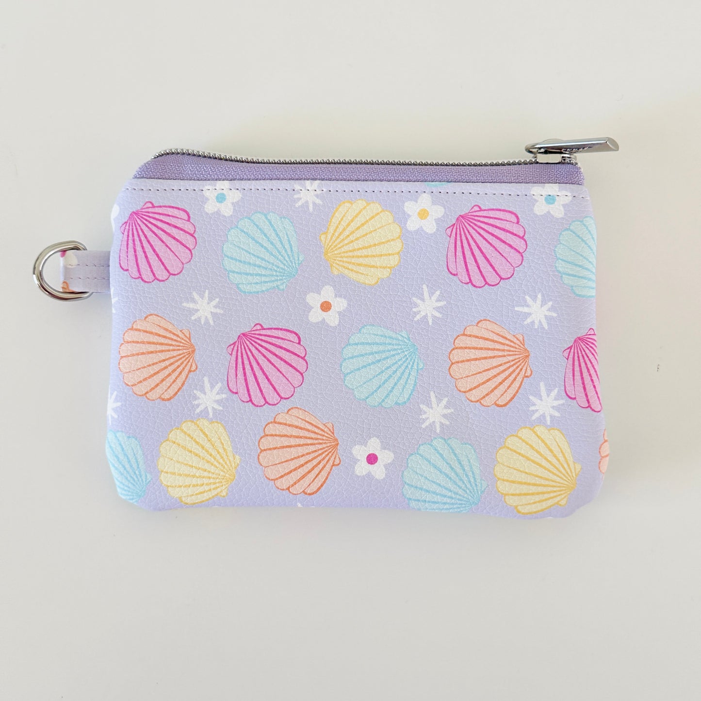 purple vegan leather coin purse with seashell pattern on a white background