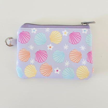 purple vegan leather coin purse with seashell pattern on a white background