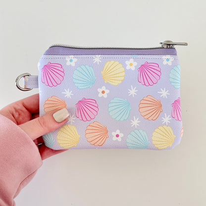 purple vegan leather coin purse with seashell pattern on a white background