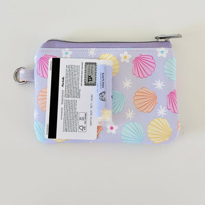 purple vegan leather coin purse with seashell pattern on a white background