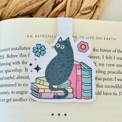 Cat-shaped bookmark with flowers on a book