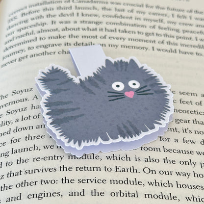 grey cat bookmark on an open book