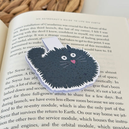 black cat bookmark on an open book