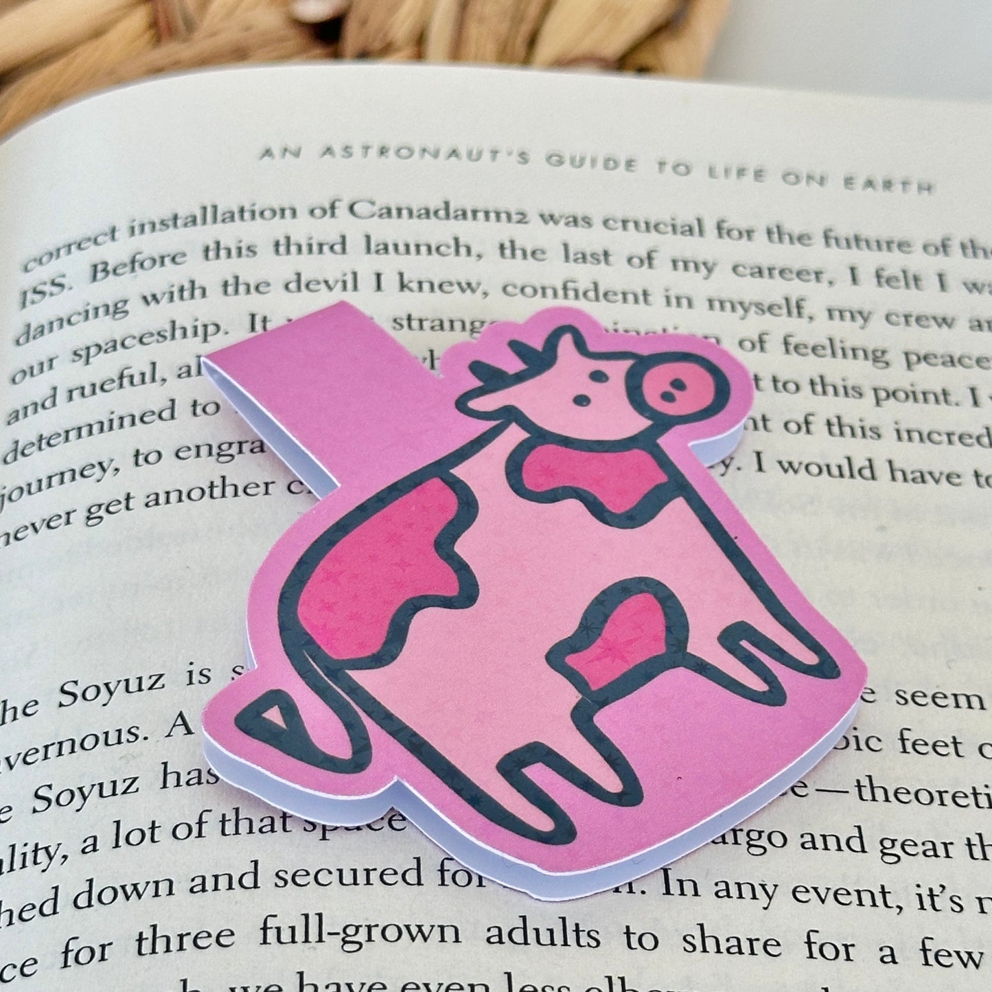 Pink cow-shaped magnetic bookmark on a Blush Stitch Studio card against a gray fur background