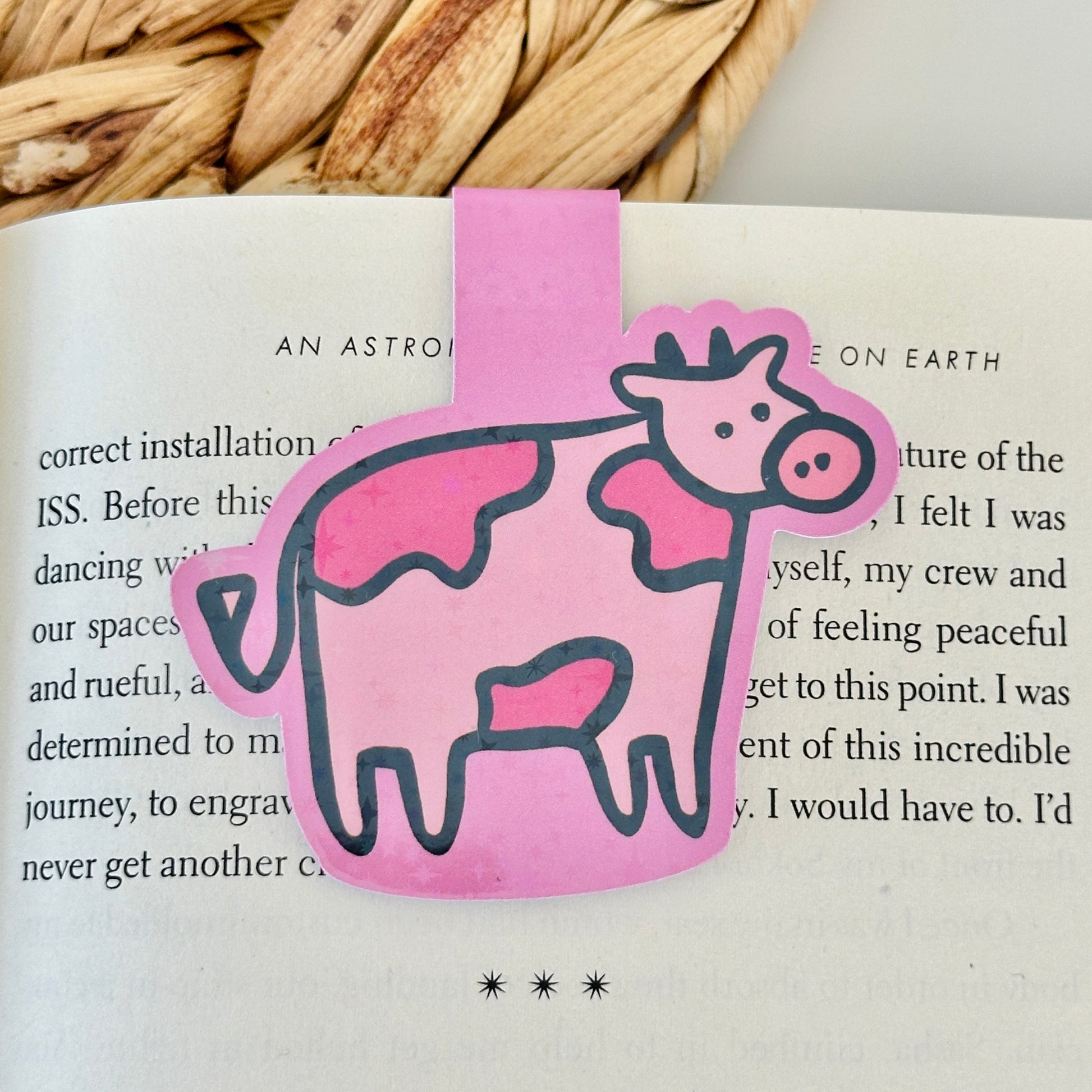 Pink cow-shaped magnetic bookmark on a Blush Stitch Studio card against a gray fur background