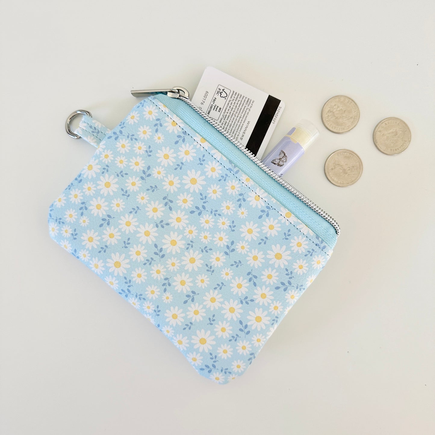 blue daisy Floral-patterned coin purse  with coins and cards on a light background