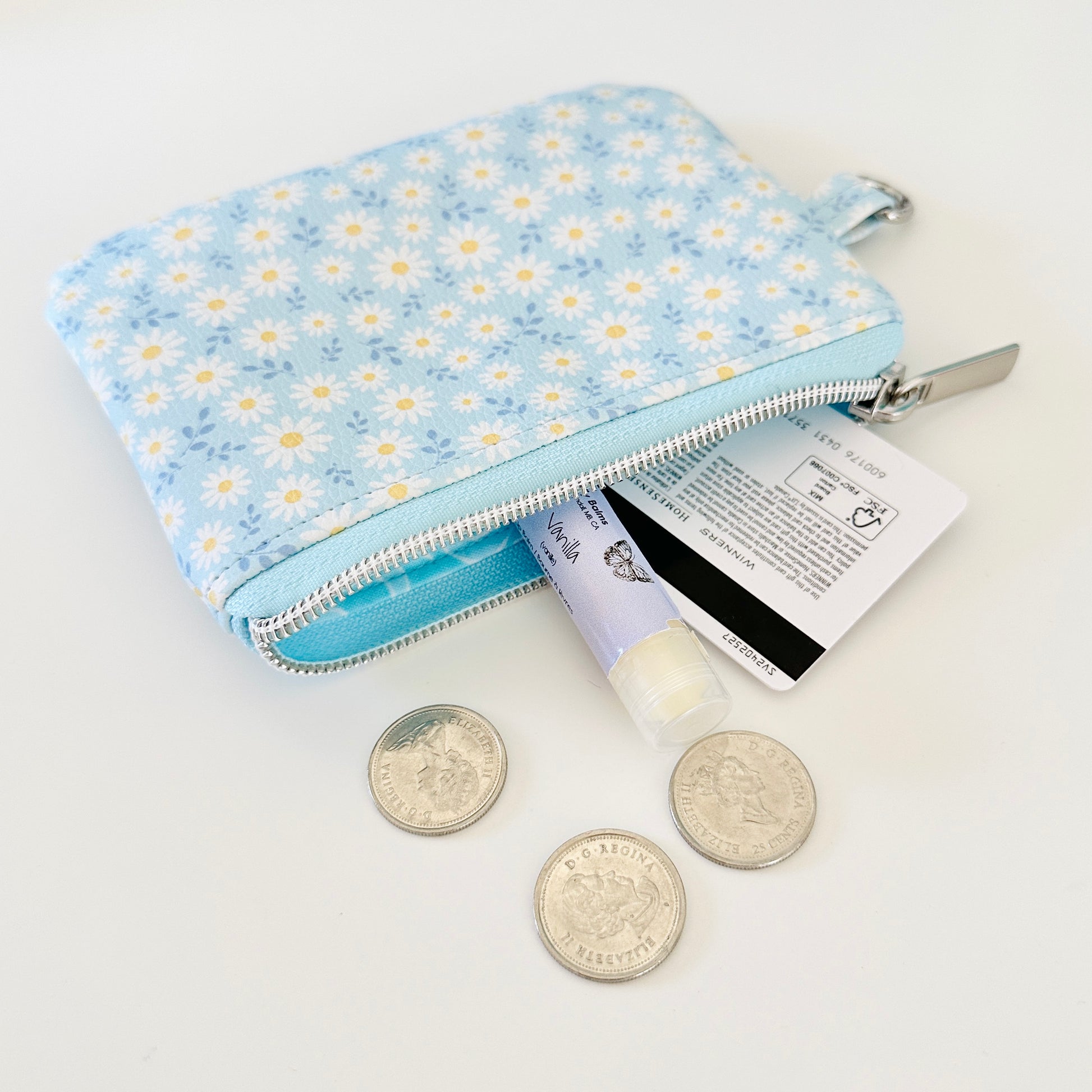 blue daisy Floral-patterned coin purse  with coins and cards on a light background
