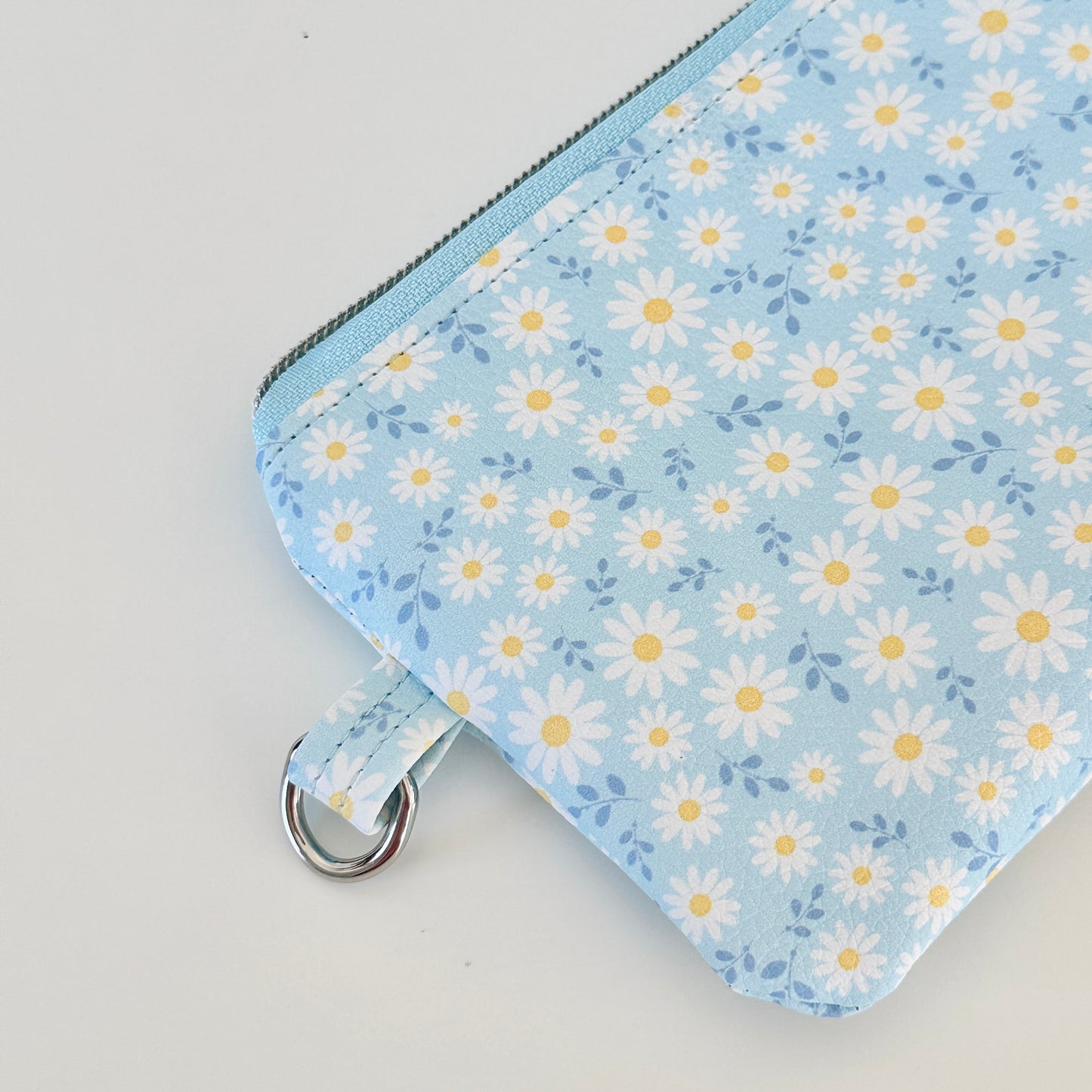 blue daisy Floral-patterned coin purse  with coins and cards on a light background