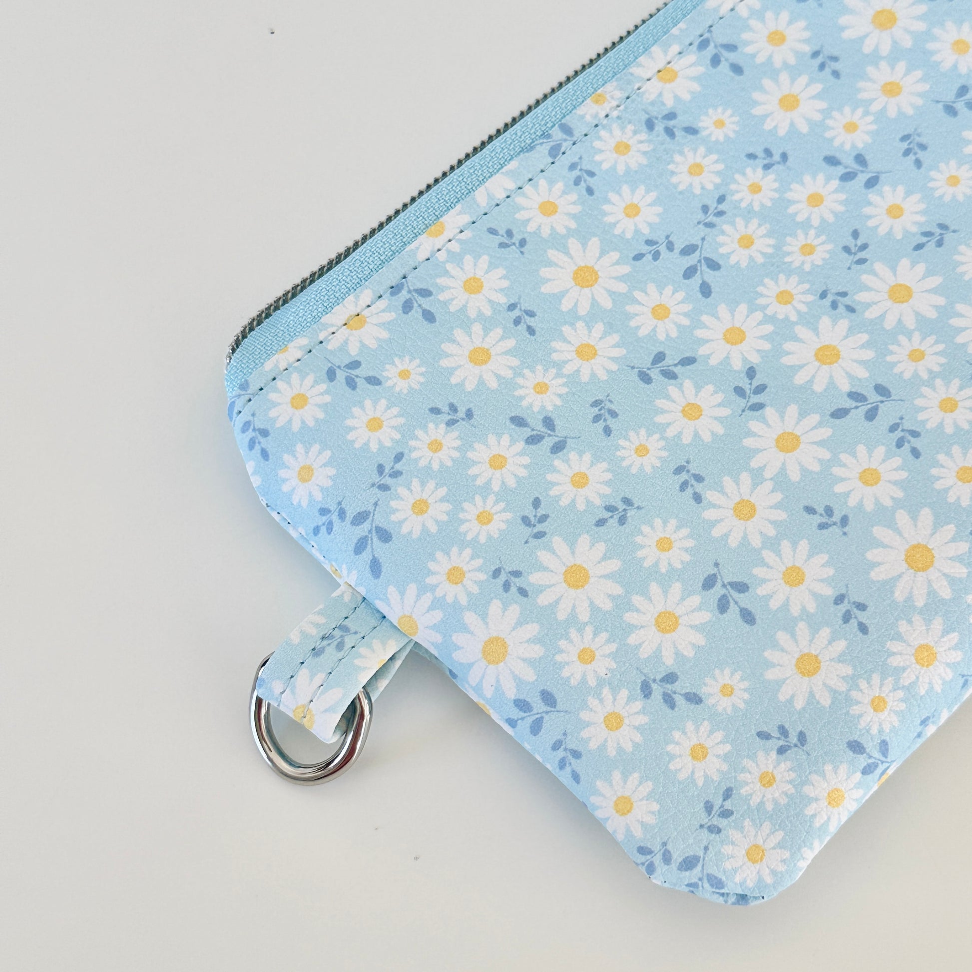 blue daisy Floral-patterned coin purse  with coins and cards on a light background