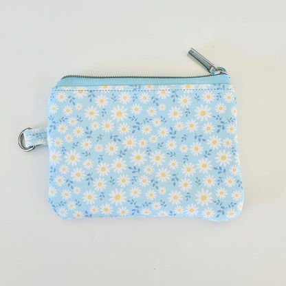 blue daisy Floral-patterned coin purse  with coins and cards on a light background