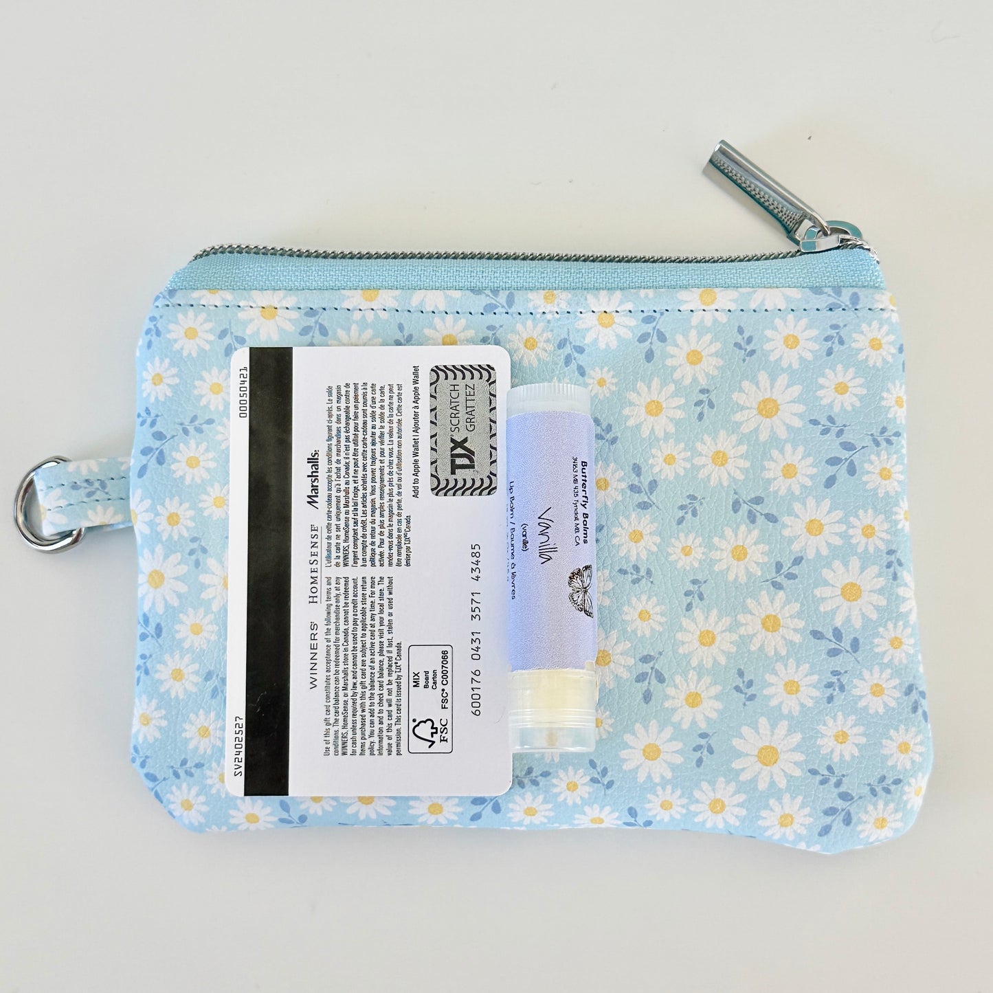 blue daisy Floral-patterned coin purse  with coins and cards on a light background