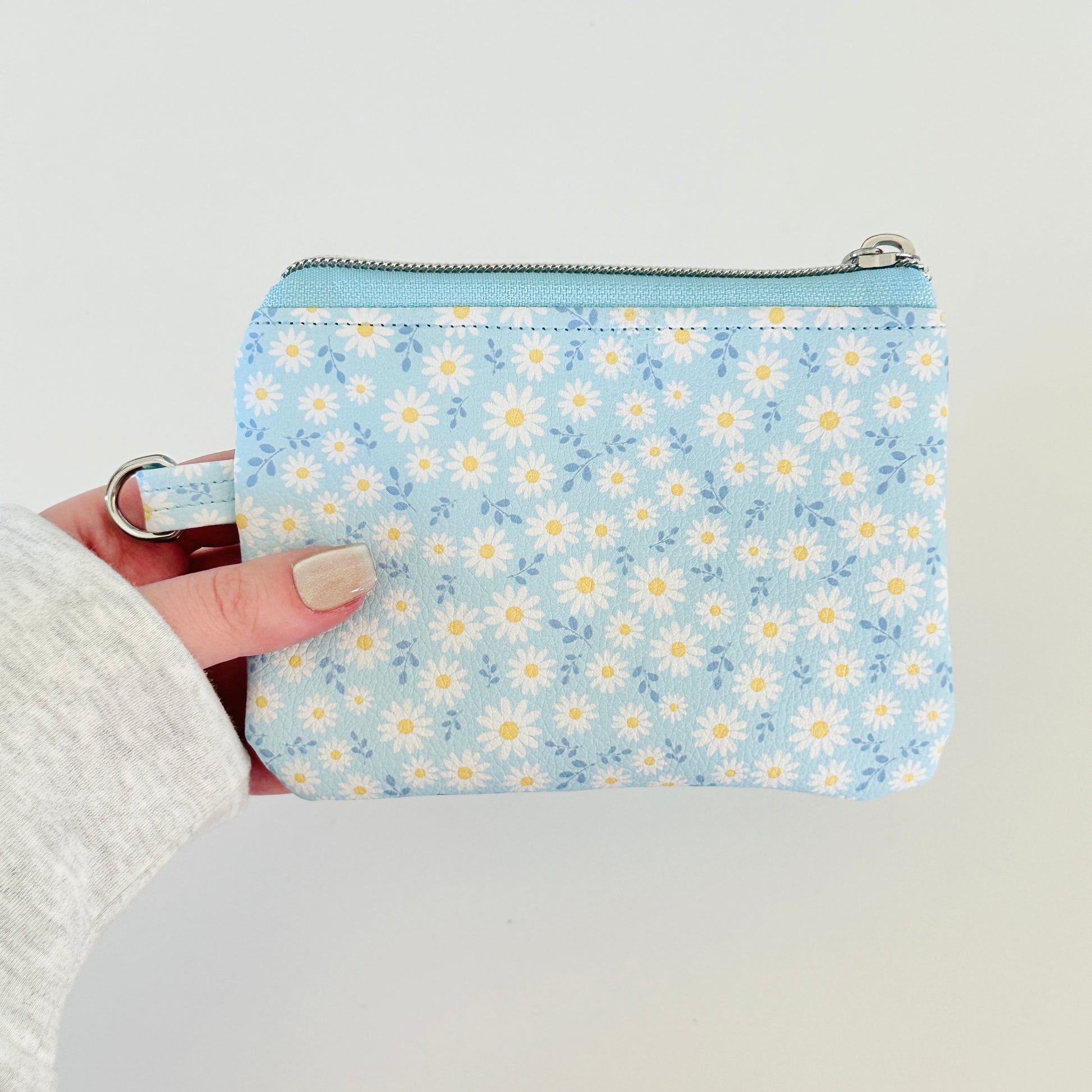 blue daisy Floral-patterned coin purse  with coins and cards on a light background