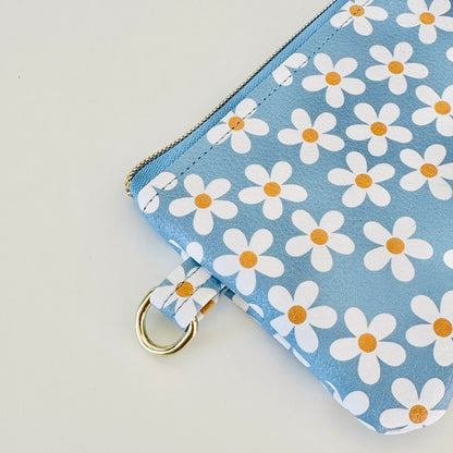 Blue floral daisy patterned coin purse with coins and cards on a white background