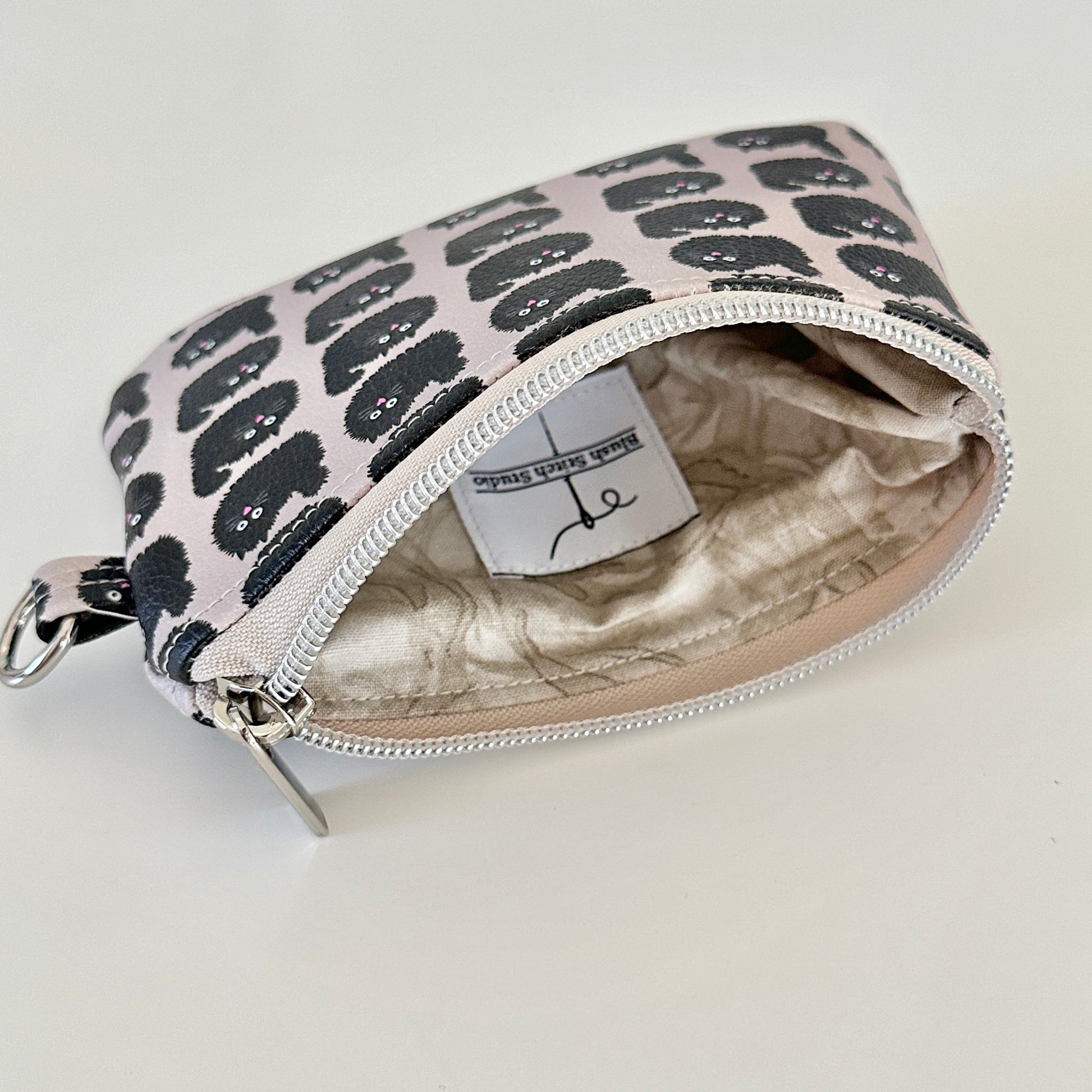 coin purse with a black cat pattern on a light background