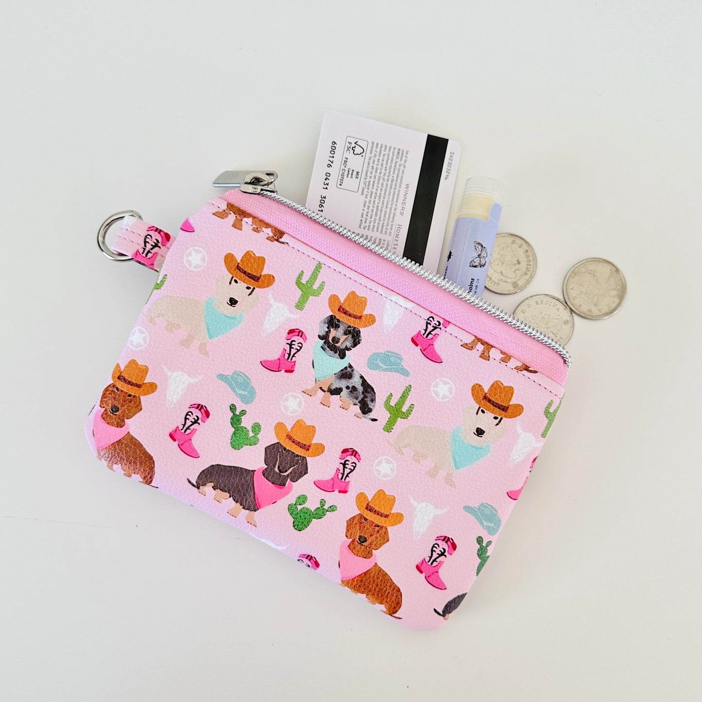 Pink coin purse with dog pattern on a white background