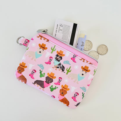 Pink coin purse with dog pattern on a white background