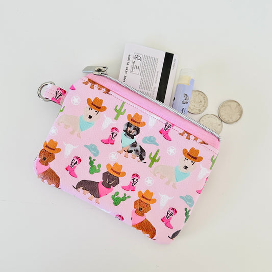 Pink coin purse with dog pattern on a white background