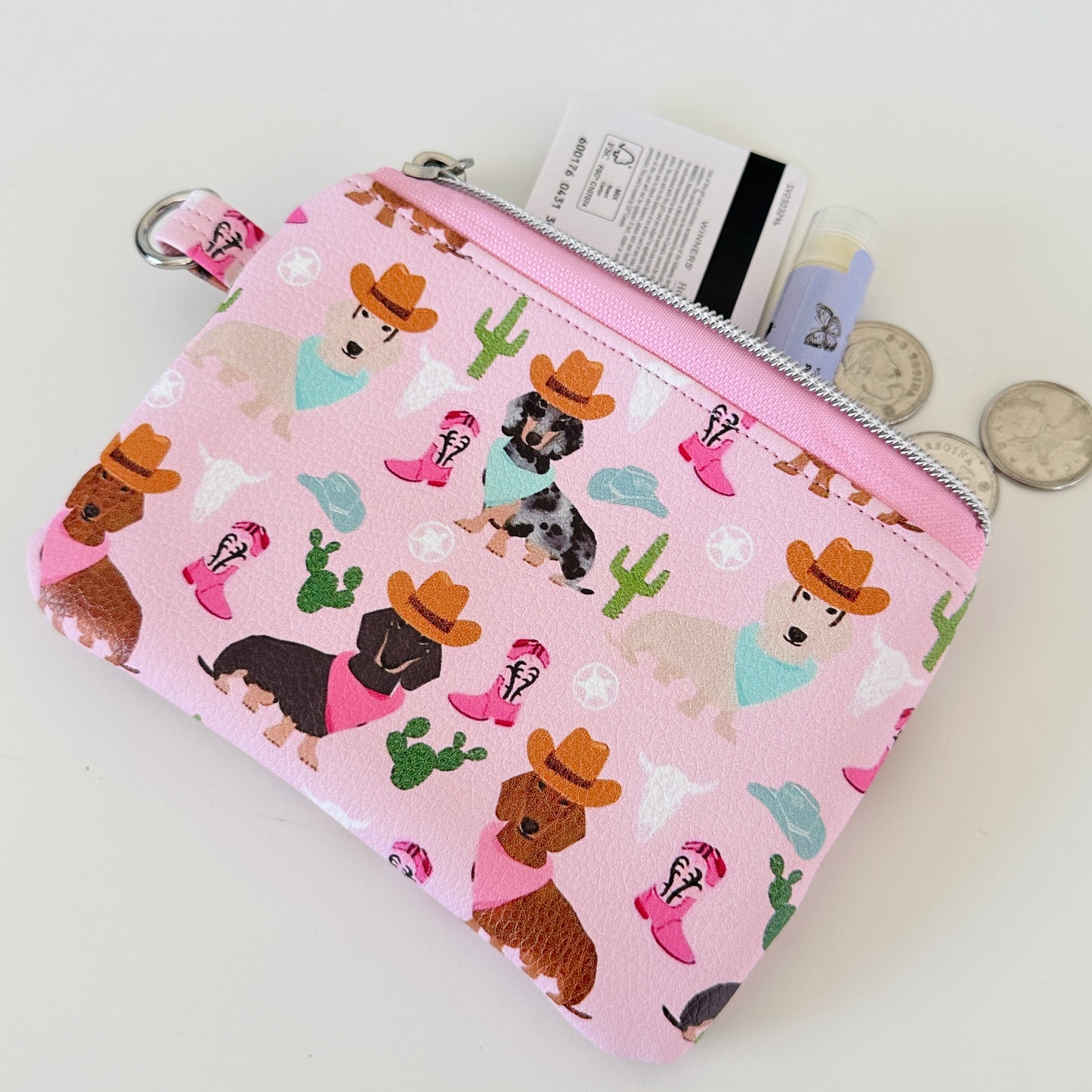 Pink coin purse with dog pattern on a white background