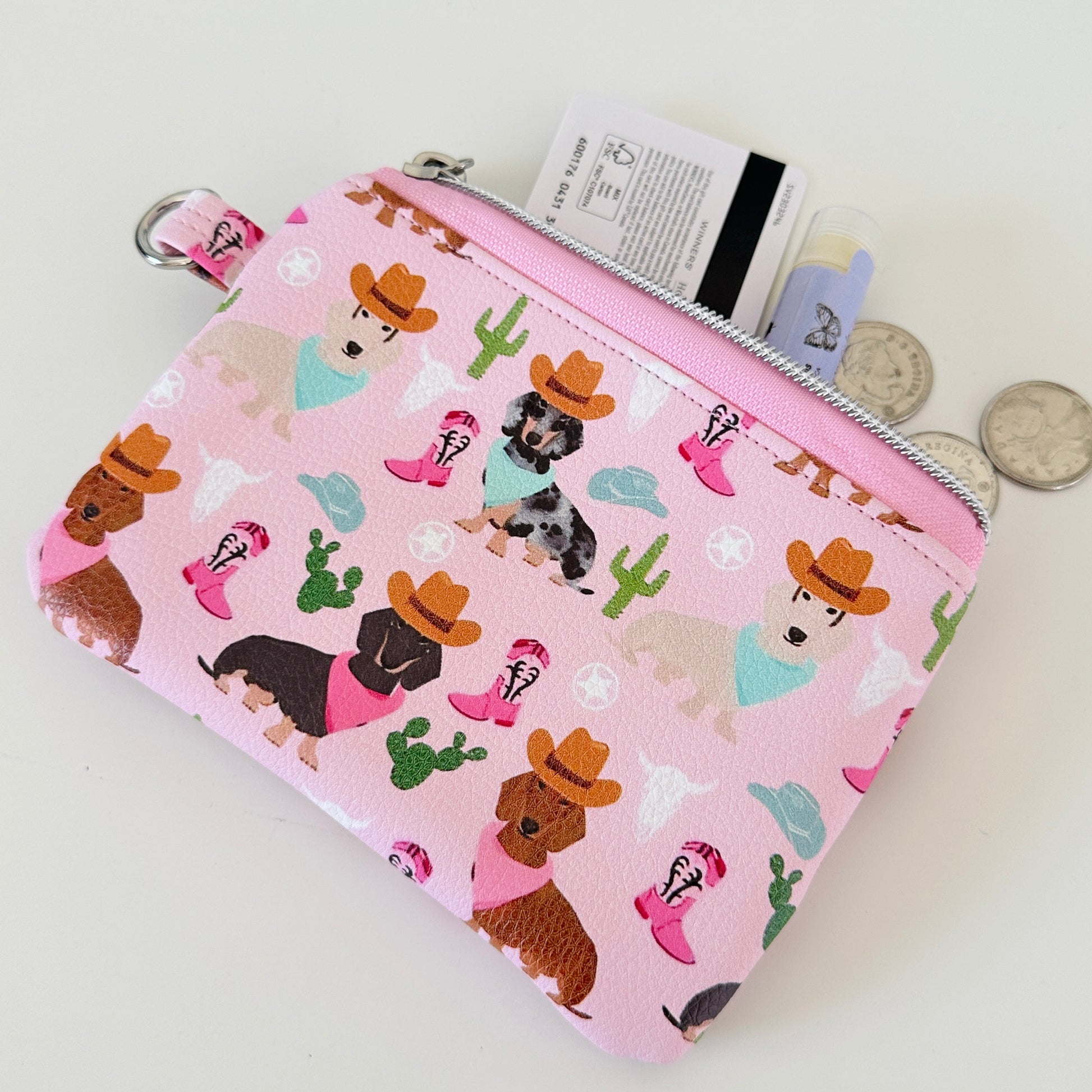 Pink coin purse with dog pattern on a white background