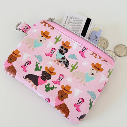 Pink coin purse with dog pattern on a white background
