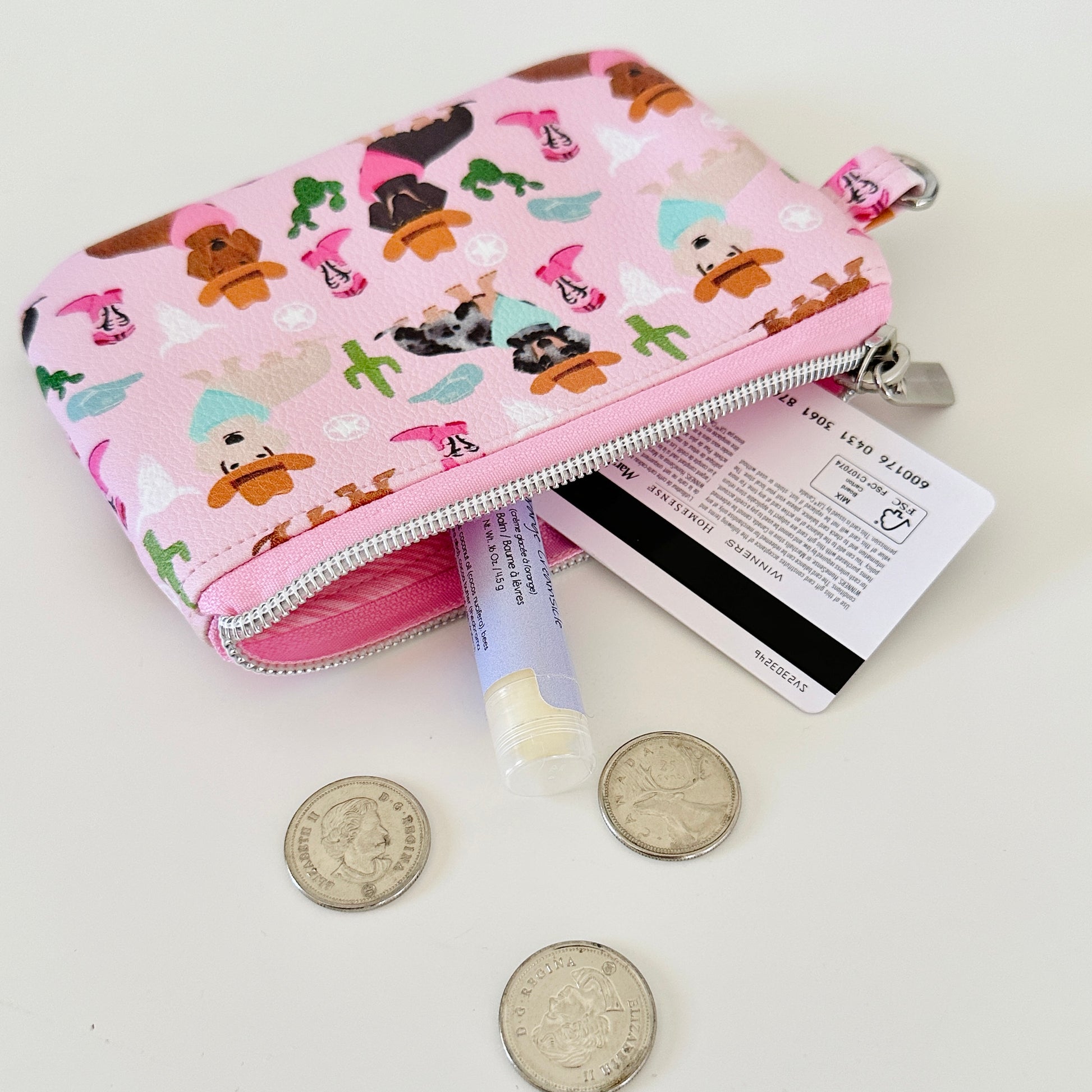 Pink coin purse with dog pattern on a white background