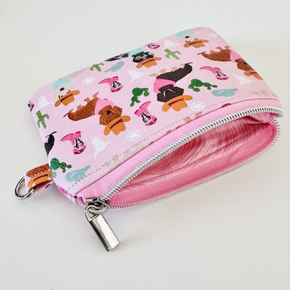 Pink coin purse with dog pattern on a white background