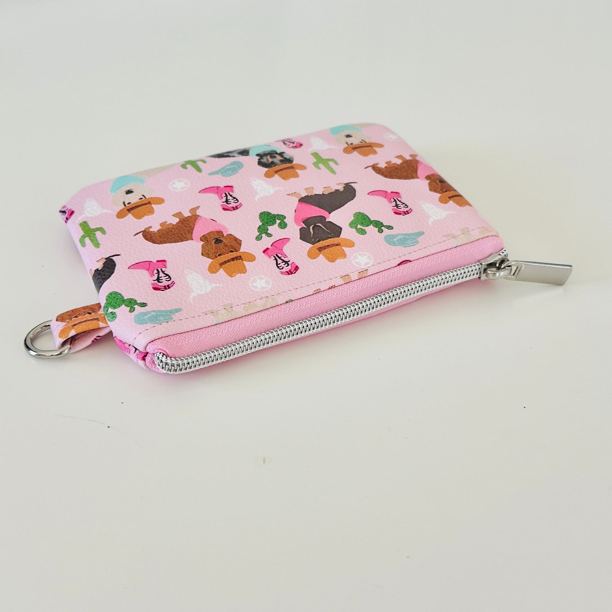 Pink coin purse with dog pattern on a white background