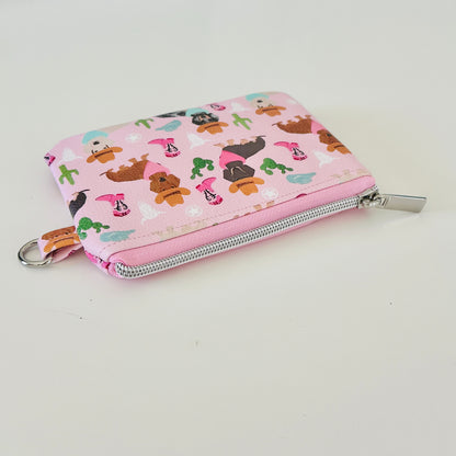Pink coin purse with dog pattern on a white background