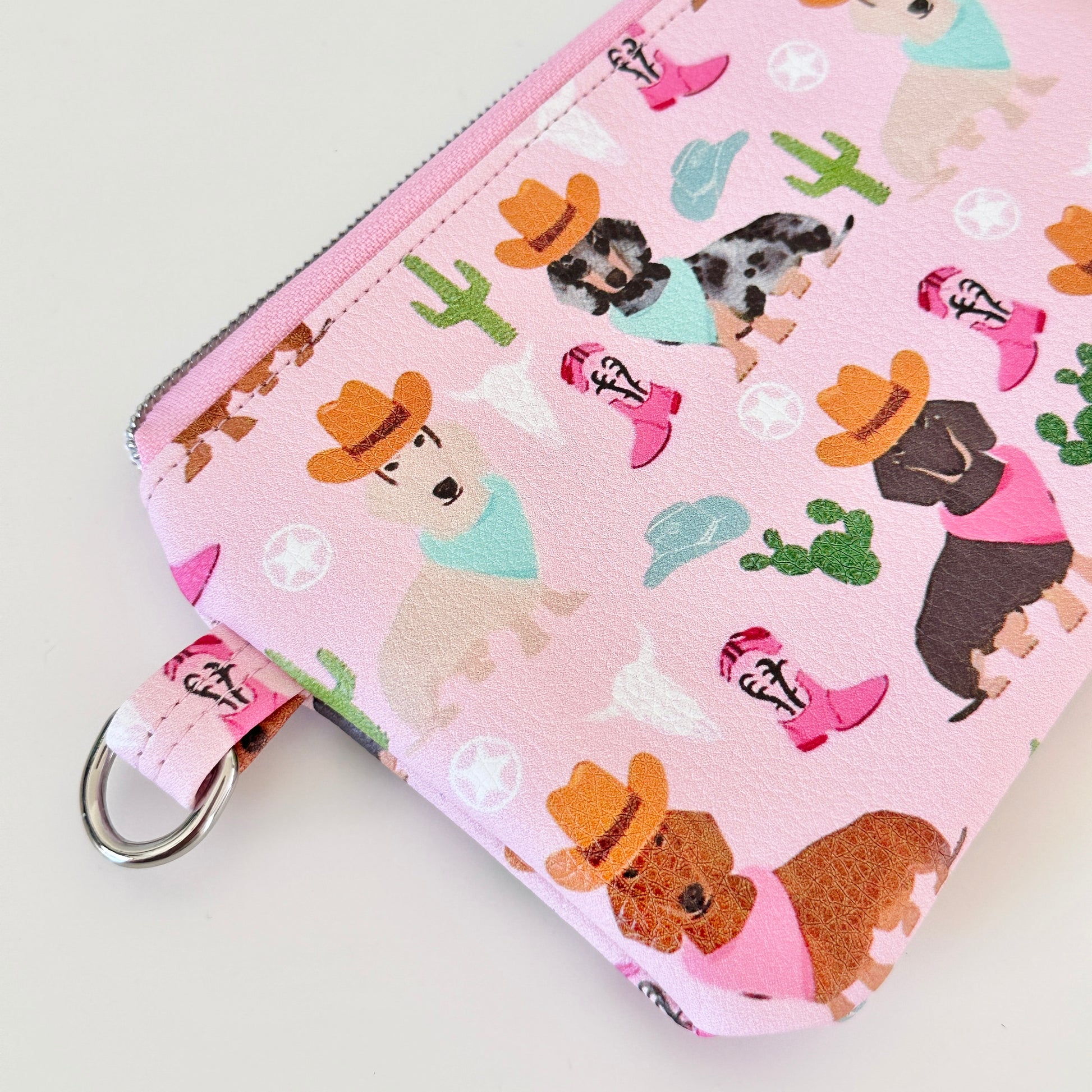 Pink coin purse with dog pattern on a white background