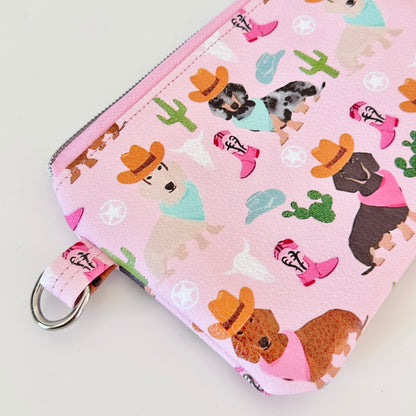 Pink coin purse with dog pattern on a white background