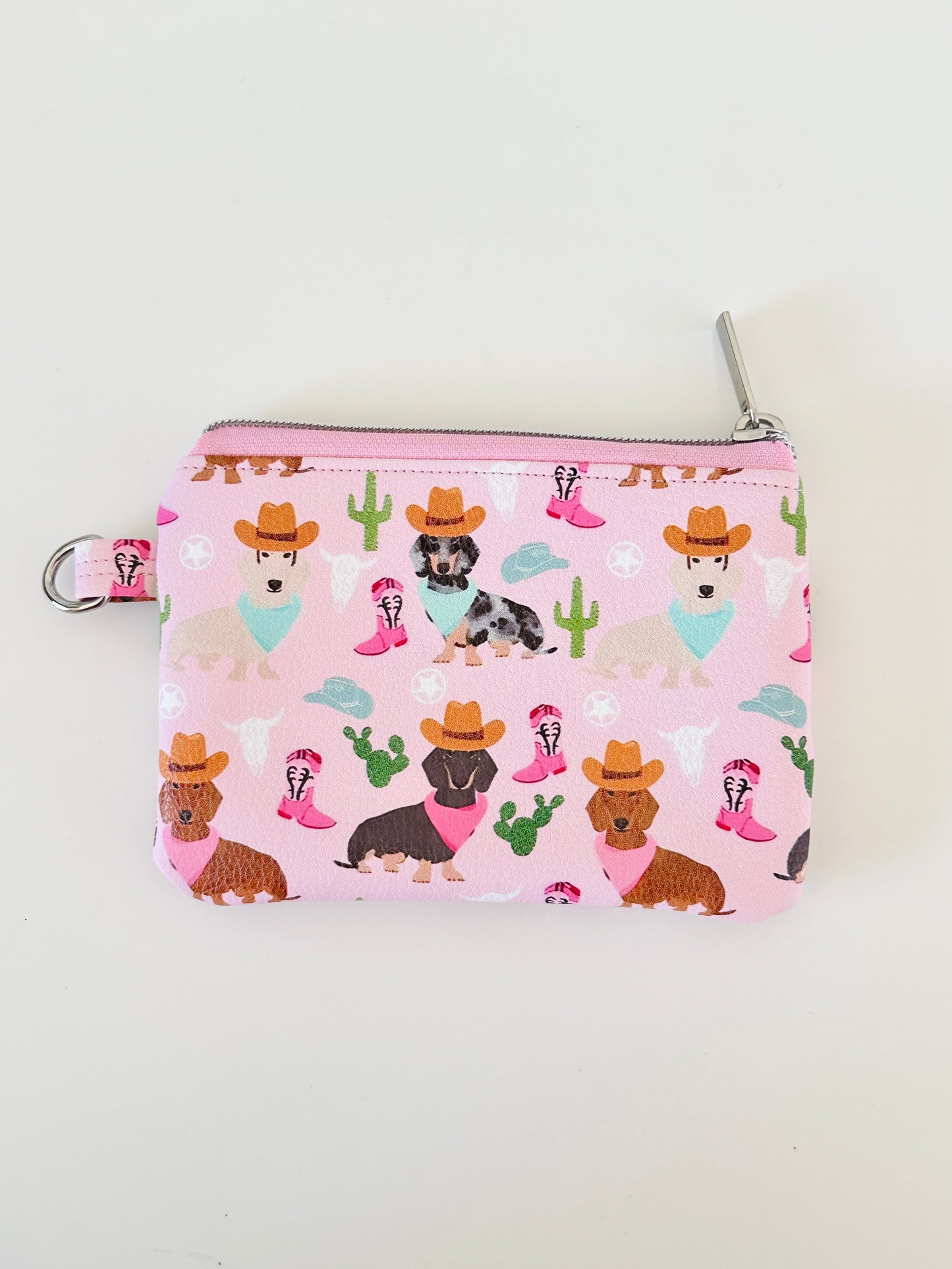 Pink coin purse with dog pattern on a white background