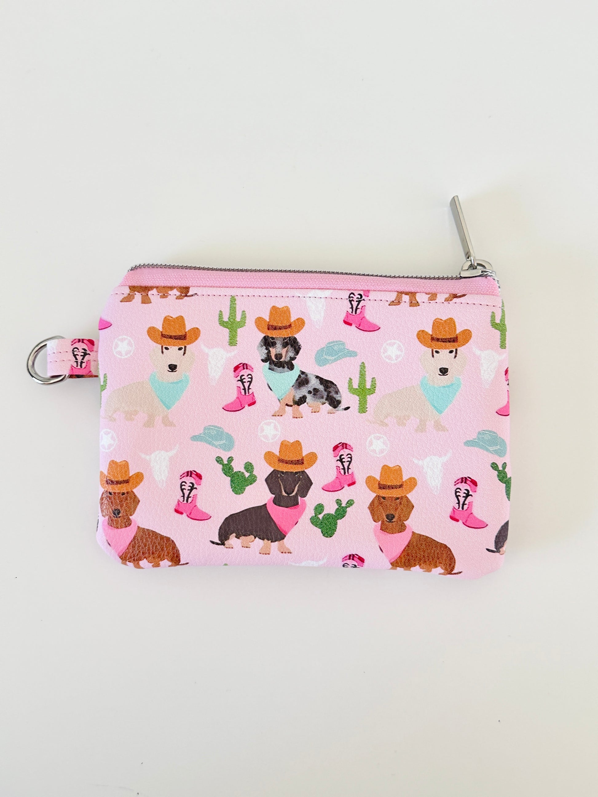 Pink coin purse with dog pattern on a white background
