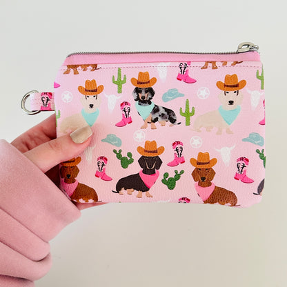 Pink coin purse with dog pattern on a white background