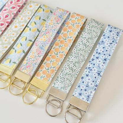 Set of floral patterned keychains on a light background