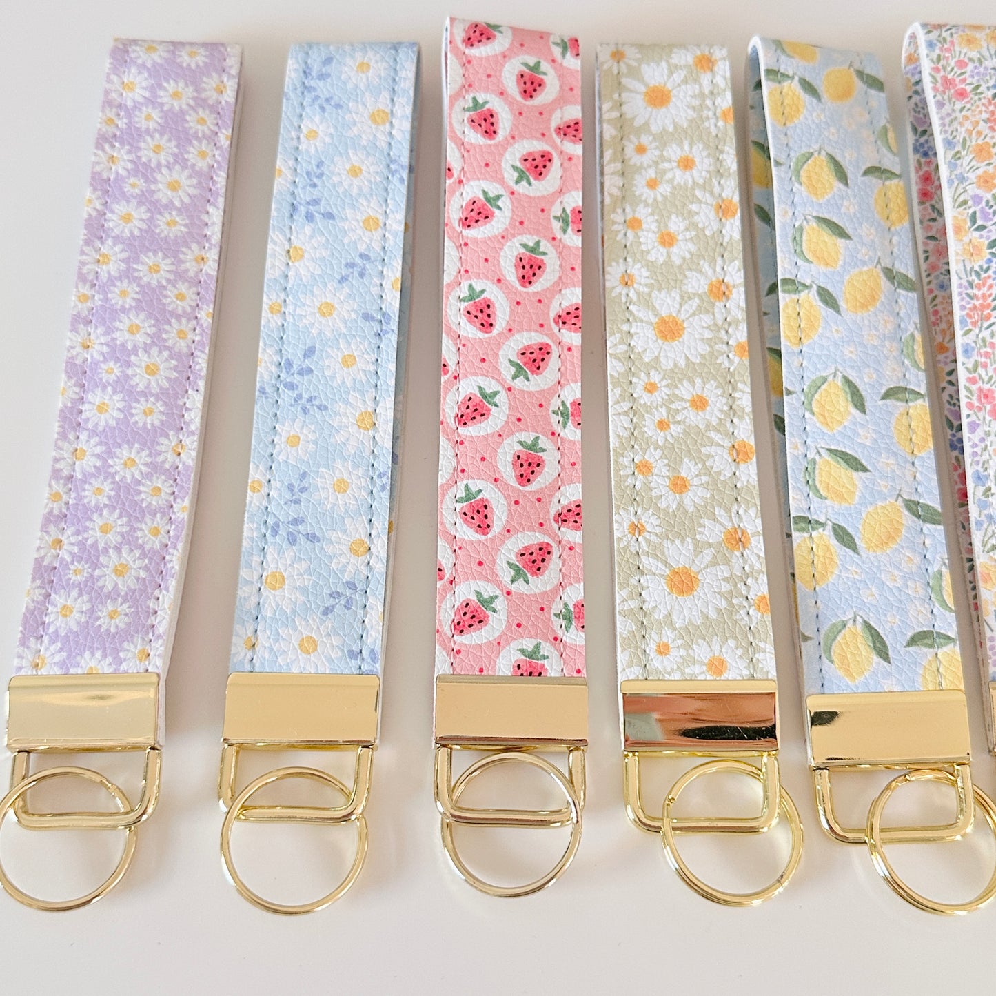 Set of keychains with colorful patterns and gold clasps on a white background