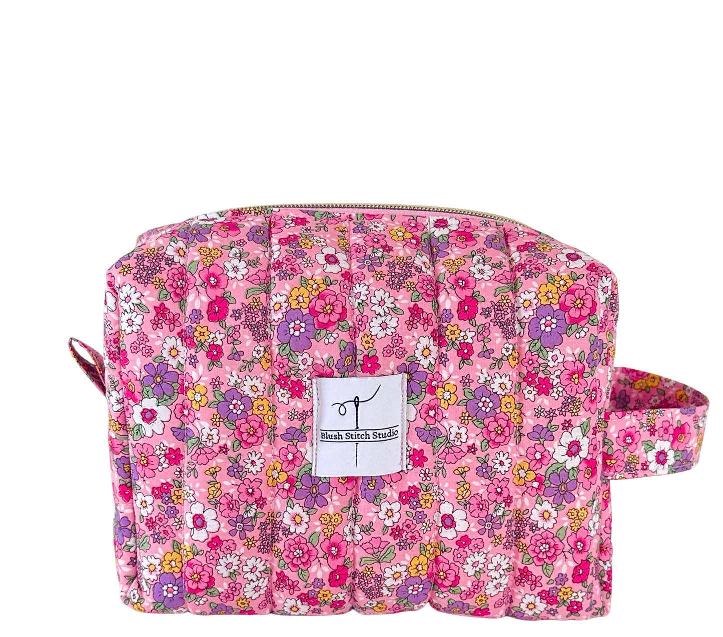 Floral patterned quilted pouch with a visible brand label on a white background