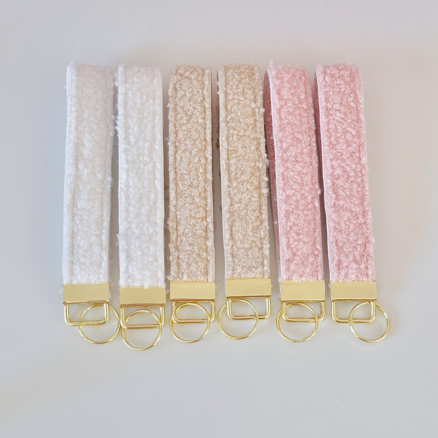sherpa fleece , teddy key wristlets, in beige and pink with gold hardware.