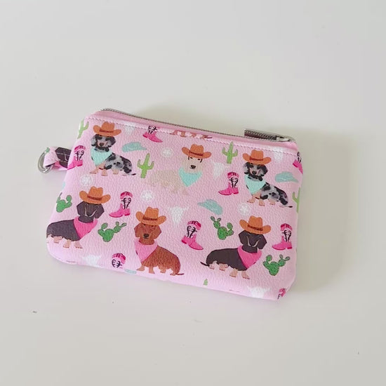 Pink coin purse with dog pattern on a white background
