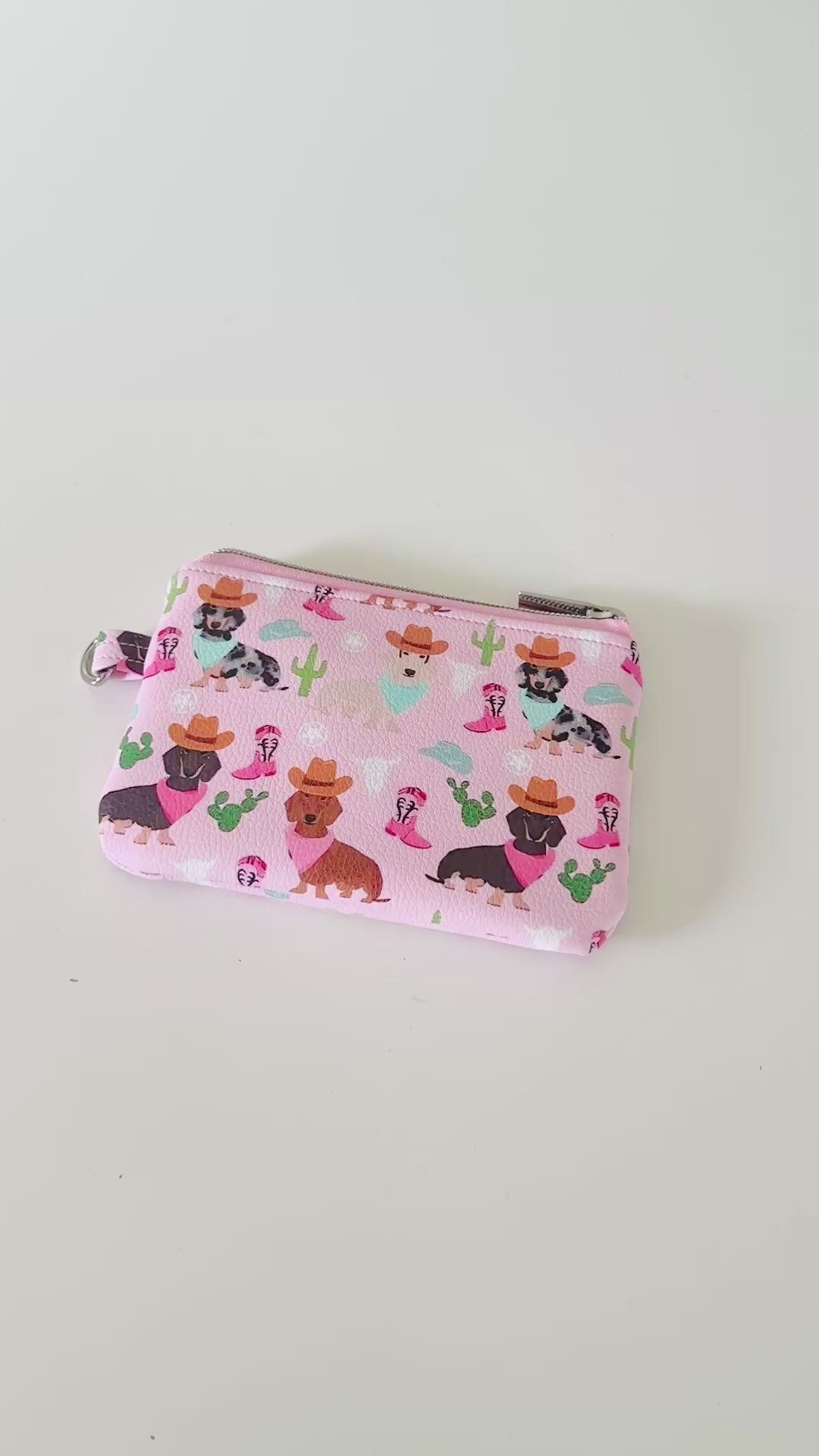 Pink coin purse with dog pattern on a white background