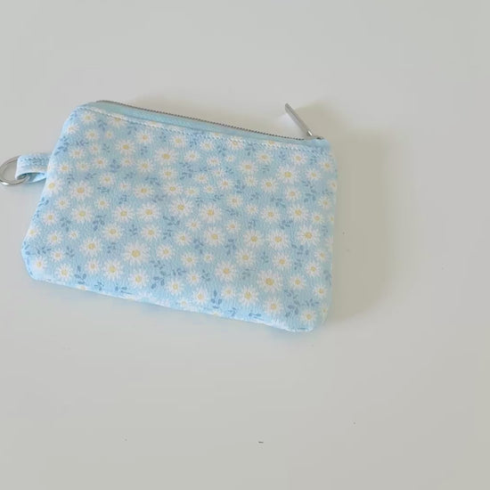 blue daisy Floral-patterned coin purse  with coins and cards on a light background