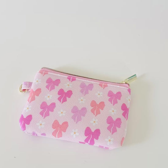 Pink coquette bow vegan leather coin purse with butterfly pattern on a white background