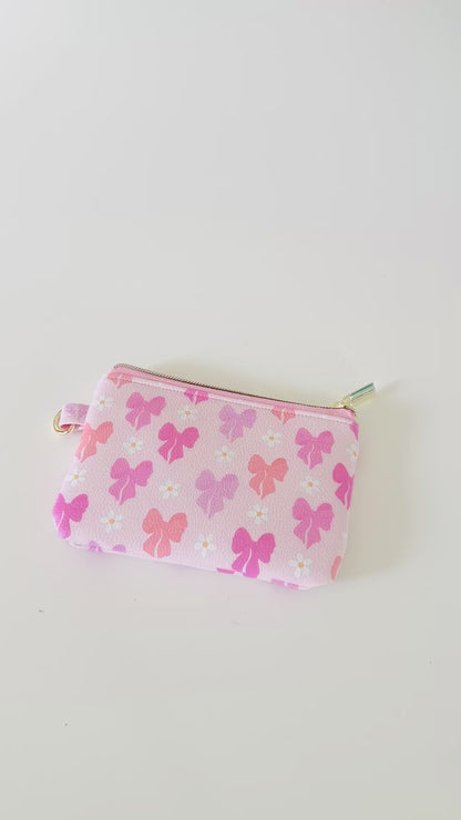Pink coquette bow vegan leather coin purse with butterfly pattern on a white background