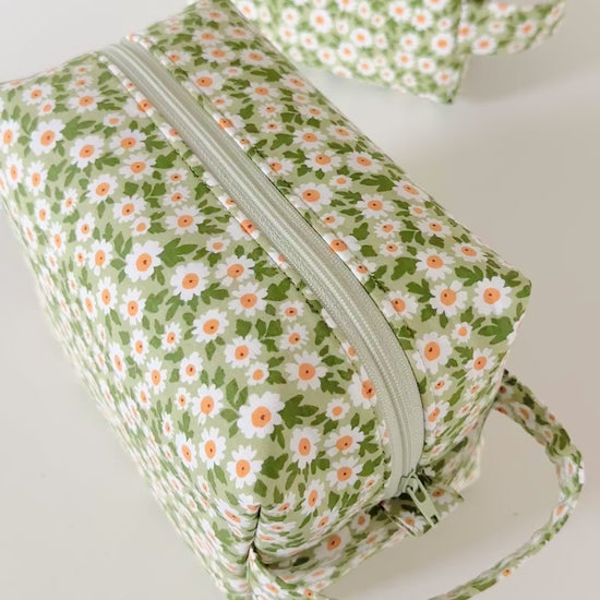 Set of three floral-patterned bags on a light gray background