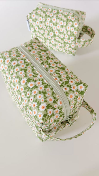 Set of three floral-patterned bags on a light gray background
