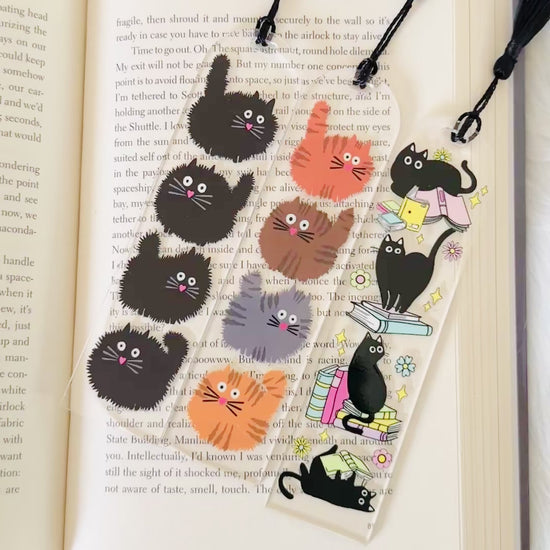 3 cat bookmarks sitting on an open book