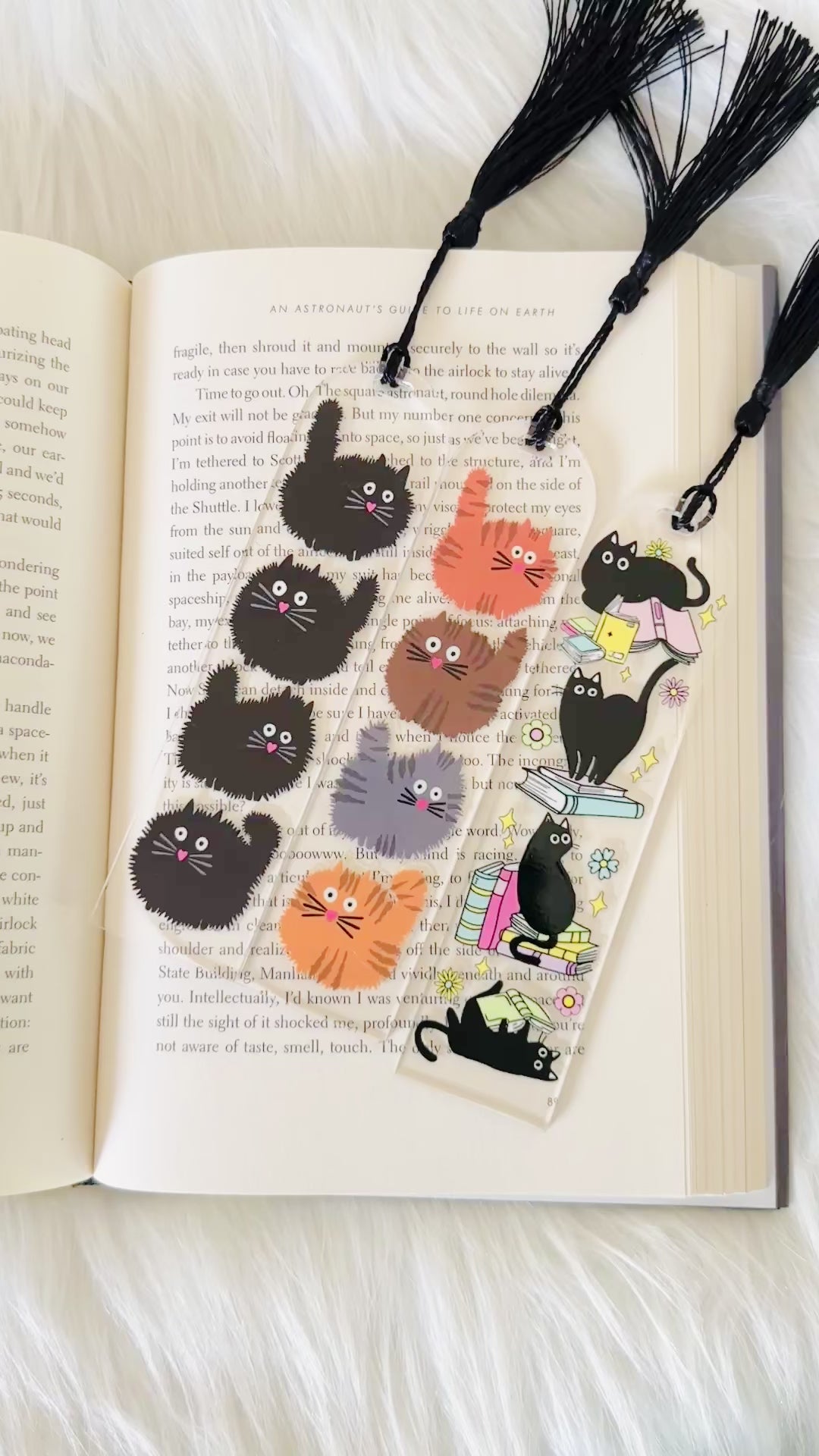 3 cat bookmarks sitting on an open book