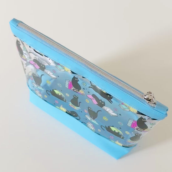 clear makeup bag with a black cat and book pattern pink bottom