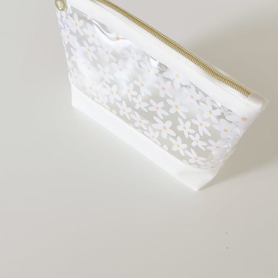 Clear pouch with white floral pattern on a light gray background