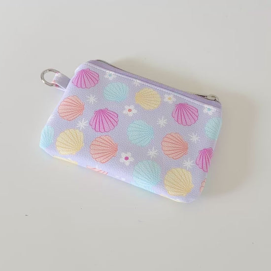 purple vegan leather coin purse with seashell pattern on a white background